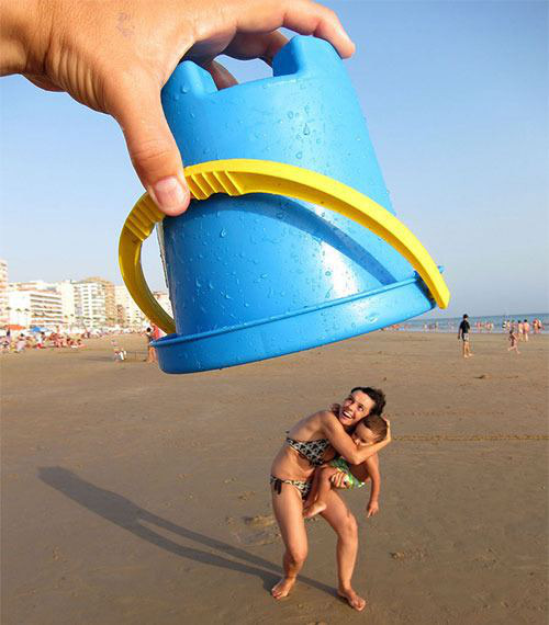 forced perspective image of a sand bucket on a beach